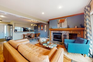 Relax in this stylish living room with a cozy fireplace, comfortable seating, and a dining area.