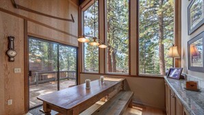 Un intérieur en bois avec une grande fenêtre, un banc et une table.