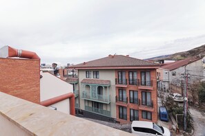 Un edificio de varios pisos con techo de tejas rojas, balcones y fachada de ladrillo.