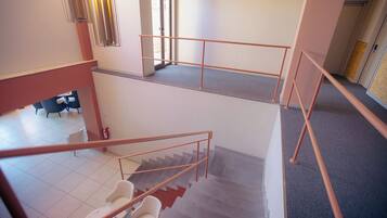 A multi-level interior with a staircase, a fire extinguisher, and a seating area.