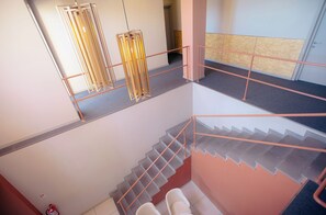 A multi-level interior with a staircase, metal railings, and a fire extinguisher. - KING TAMAR HOTEL By LUXURIA HOTELS (Tbilisi)