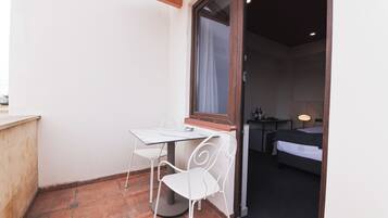 A small room with a bed, a desk, and a chair.