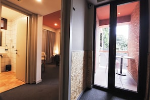A hotel corridor with a bathroom, a seating area, and a view of the outside. - KING TAMAR HOTEL By LUXURIA HOTELS (Tbilisi)