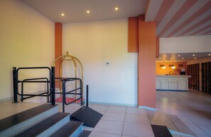 A hotel lobby with a staircase, a wheelchair lift, and a reception area. - KING TAMAR HOTEL By LUXURIA HOTELS (Tbilisi)