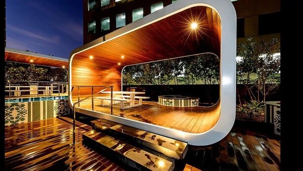 Ein Außenpoolbereich mit Holzterrasse, einer Lounge-Ecke und modernem architektonischen Design.