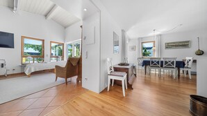 A spacious room with a bed, a dining area, and a view of the outdoors.