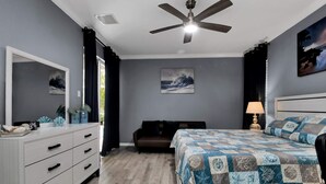 A bedroom with a bed, a nightstand, a dresser, a ceiling fan, and two paintings on the wall. - Stylish & Bright, Mins to Downtown, Pool, Parking (North Port)