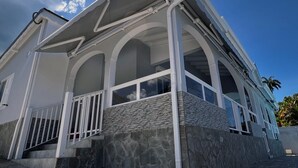 A modern house with a stone facade, large windows, and a covered porch.