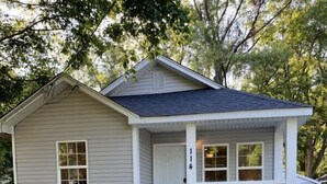 A single-story house with a front porch, a mailbox, and a small outdoor seating area with two chairs. - Wilson, Two Bedroom House in Historic Loveland (Loveland)