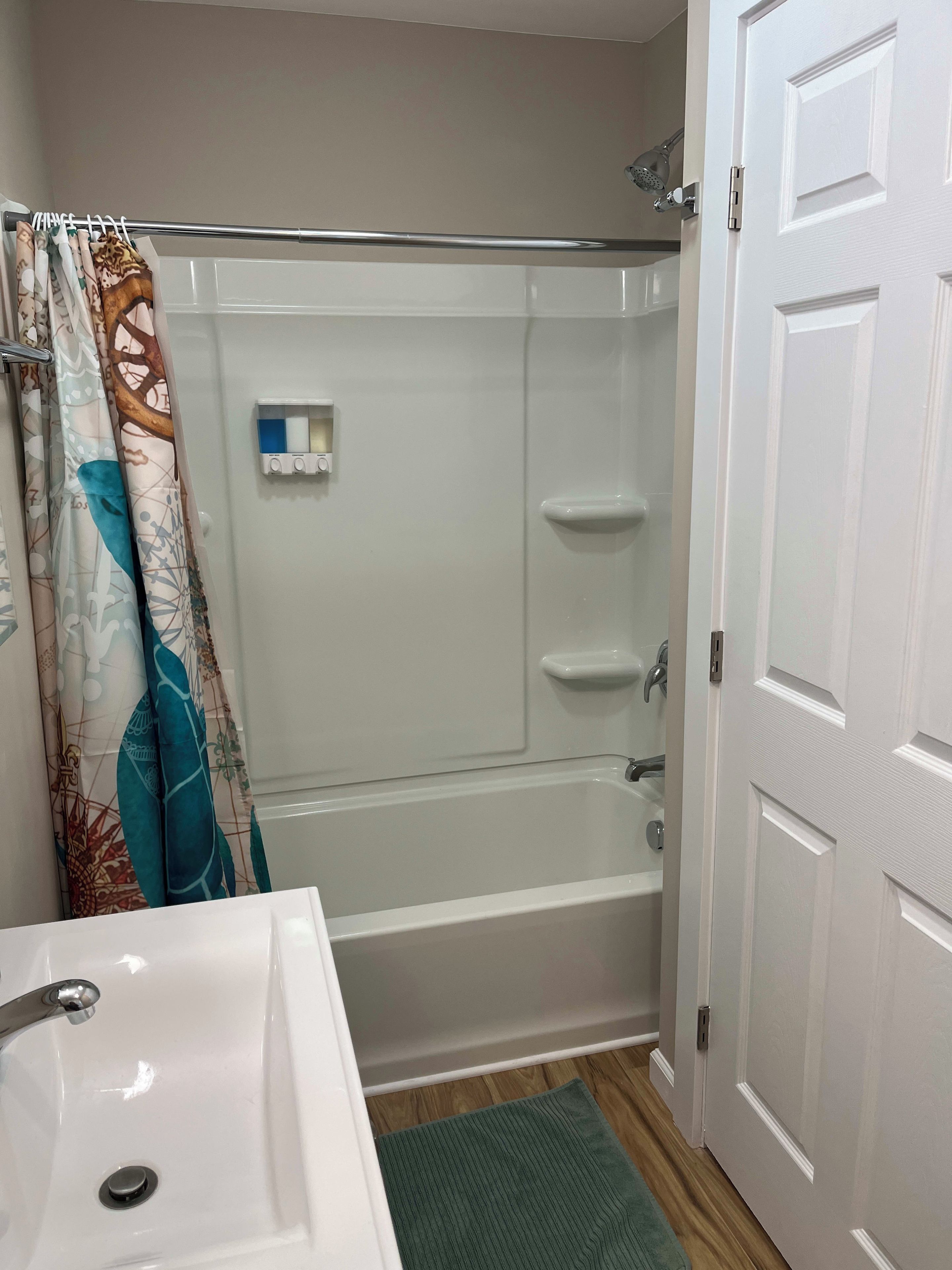 A bathroom with a shower, a toilet, and a sink.