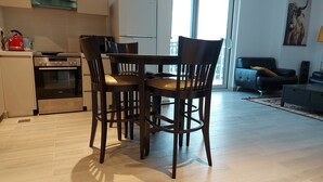 Een moderne keuken met een ingebouwde oven en een eethoek met een houten tafel en stoelen.