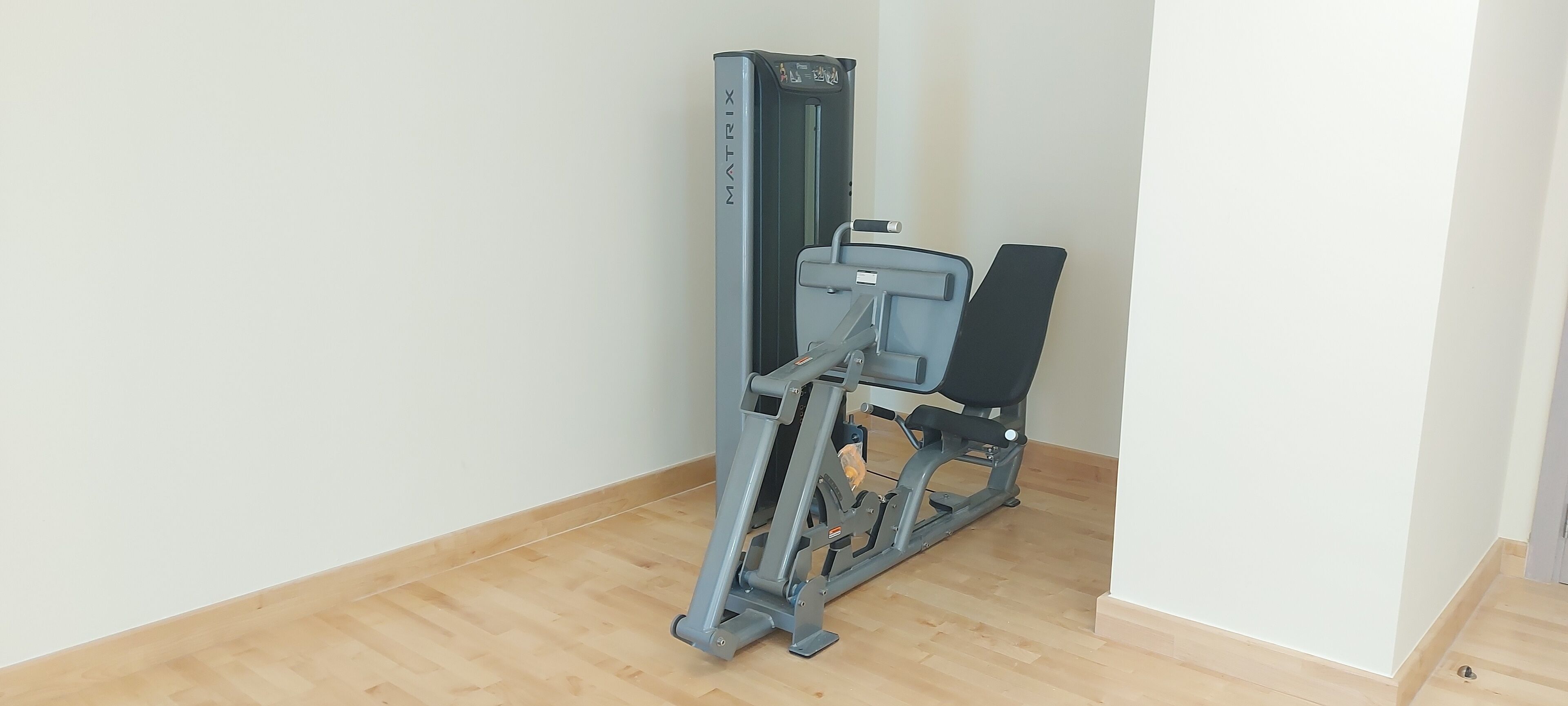 A gym with a cardio machine and a bench.