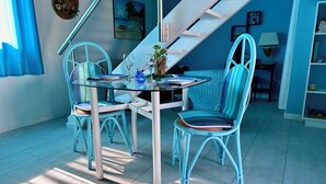 A dining area with a glass table and chairs, a staircase, and a view of the outdoors. - Studio Indépendant Devant Piscine et BBQ à Orient Bay à 5 Minutes de la Plage ! (saint martin)