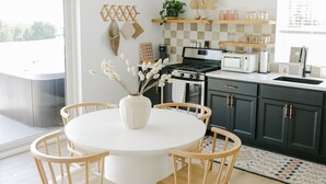 Une cuisine moderne avec une table de salle à manger ronde, des chaises en bois et un luminaire suspendu.