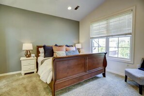 Un dormitorio con cama, mesitas de noche y ventana.