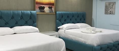 Hotelkamer met twee bedden, een schilderij van een zonsondergang en een bordje met WIFI, TV, ontbijt en koelkast.