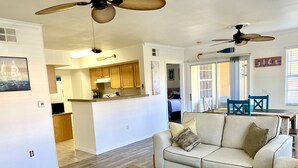 A spacious living area with a sofa, a coffee table, and a kitchen in the background. - Gated, NO stairs, NO carpet 1 min walk to lakefront POOL, PICKLEBALL/TENNIS (Sarasota)