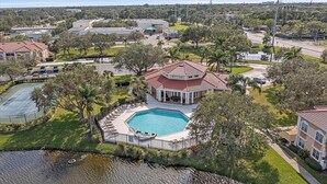 A large house with a swimming pool, surrounded by trees and a body of water. - Gated, NO stairs, NO carpet 1 min walk to lakefront POOL, PICKLEBALL/TENNIS (Sarasota)