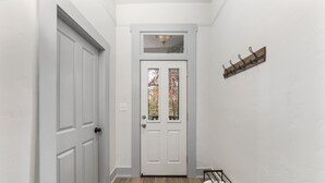 A hallway with a white door, a coat rack, and a small shelf. -  New/Midtown Sac/Free Parking/Coffee/Long stays welcomed (Sacramento)