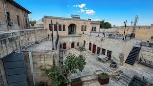 Un cortile con edifici in pietra, posti a sedere all'aperto e piante in vaso.