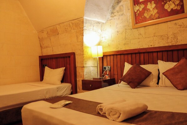 A hotel room with two single beds, wooden headboards, a nightstand with a lamp, and a framed picture on the wall. - Müzepotamia Butik Hotel (Sanliurfa)