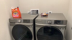 Two Samsung front-loading washing machines with Tide detergent and a box of baking soda on top. - Skip the gameday/ graduation gridlock (Bryan)