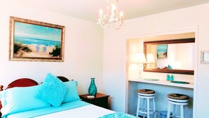 Une chambre à coucher comprenant un lit, une table de chevet, un vase, une commode, un miroir et un lustre.