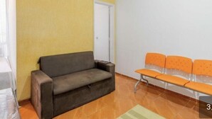A room with a sofa, a bench, and a door. - Luxury apartment by the sea (Rio de Janeiro)