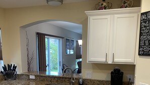 A modern kitchen with white cabinets, a stainless steel dishwasher, and granite countertops.