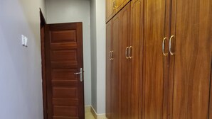 Un couloir avec une porte en bois et une armoire dotée de nombreux tiroirs et de poignées.