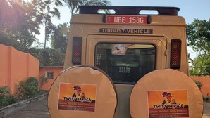 Un véhicule touristique arborant deux grands panneaux circulaires faisant la publicité des safaris et des voyages organisés par Twist Africa.