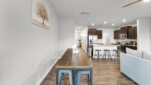 Una cocina moderna con armarios de madera, una isla central y taburetes de bar.