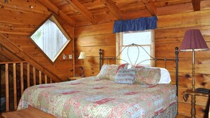 A wooden cabin bedroom with a bed, a window, a lamp, and a wooden ceiling. - Romantic Secluded Cabin in Gatlinburg with Great Mountain View (Gatlinburg)
