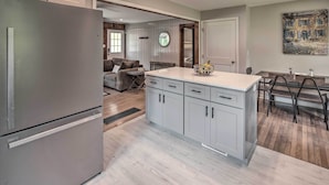 A modern kitchen with a built-in refrigerator, grey cabinets, and a dining area with a table and chairs. - Cozy Arden Cottage, 2 Mi to Lake Julian Park! (Arden)