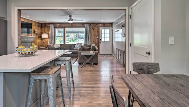A spacious kitchen with a central island, wooden flooring, and a view of the outdoors. - Cozy Arden Cottage, 2 Mi to Lake Julian Park! (Arden)