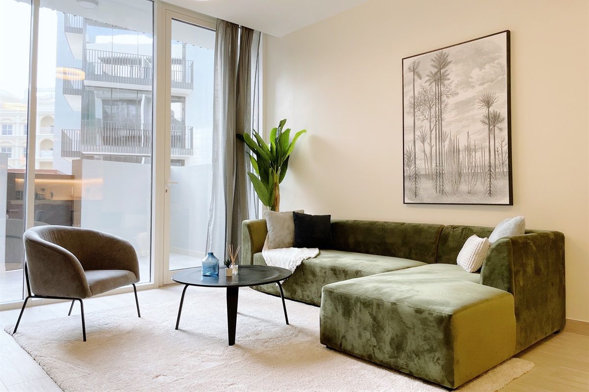 A modern living room with a sofa, armchair, and a small table.