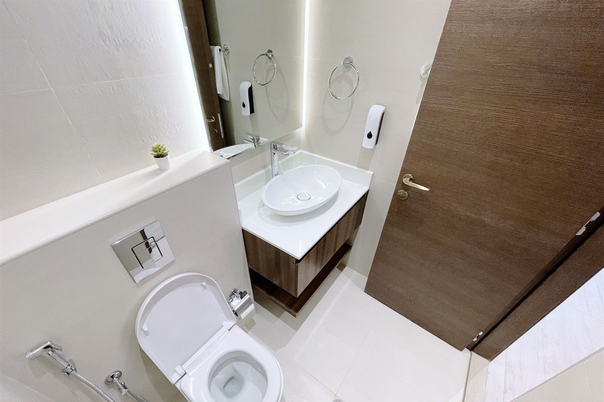 A modern bathroom with a toilet, sink, and shower.