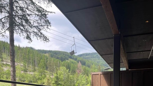 Boblebad med to vinglas og en flaske, med udsigt over et skovlandskab.