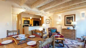 Un comedor con una mesa de madera lista para una comida, un sofá y una lámpara.