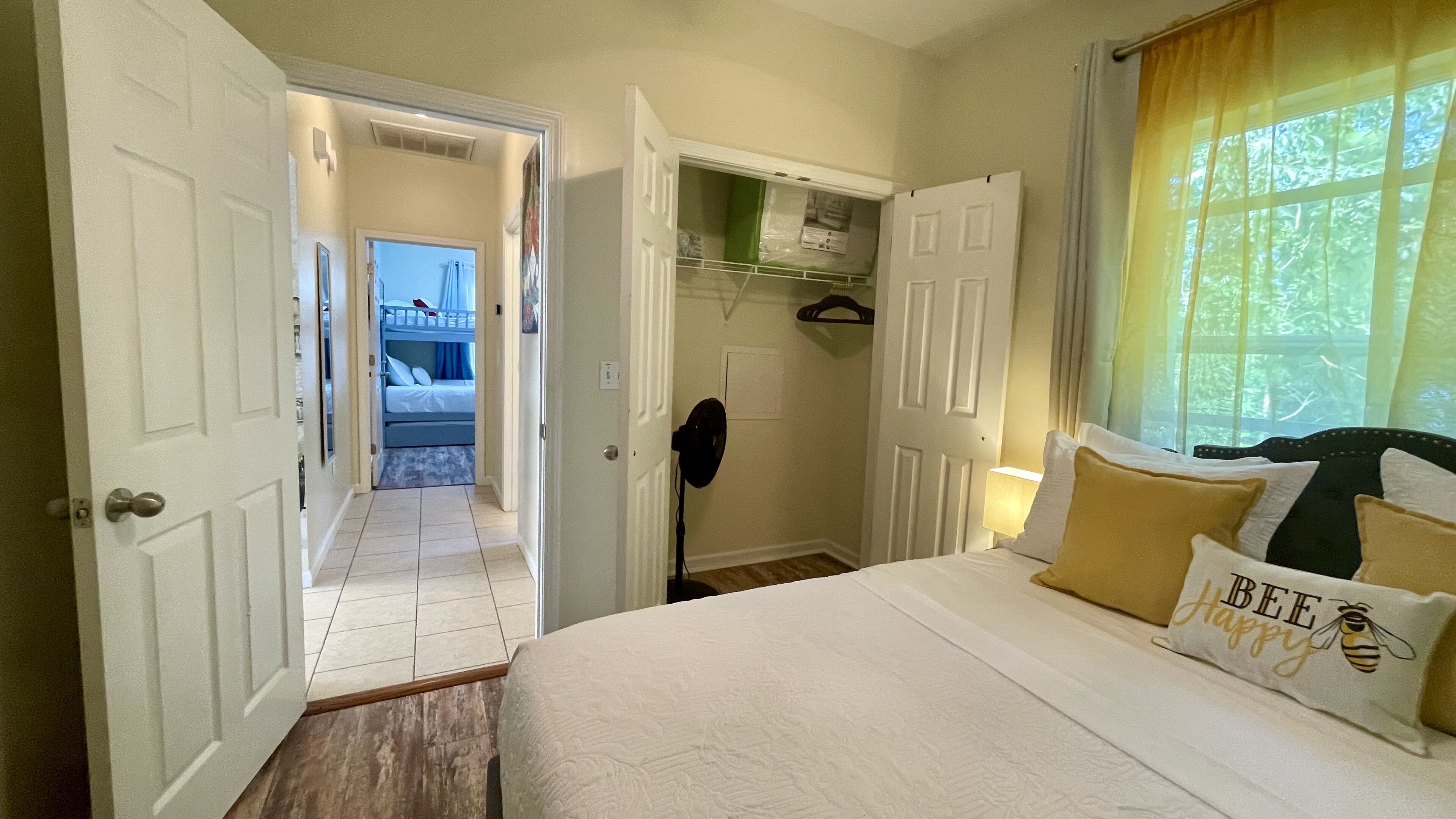 Habitación de hotel con cama, vestidor y ventana con cortinas.