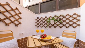 A small outdoor seating area with a table, two chairs, a wooden lattice wall, and a potted plant. - The Apolo Loft in Downtown by Florit Flats (Valencia)