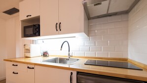 A modern kitchen with white cabinets, a stainless steel sink, a microwave, and a dishwasher. - The Apolo Loft in Downtown by Florit Flats (Valencia)