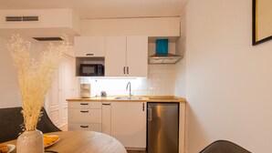 A modern kitchen with white cabinets, a stainless steel dishwasher, and a microwave. - The Apolo Loft in Downtown by Florit Flats (Valencia)