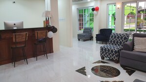 A modern reception area with a desk, chairs, and a sofa.