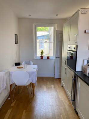 Enjoy meals in this kitchen with an oven, refrigerator, and dining table for two.