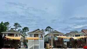 Filas de casas de playa con terrazas al aire libre y escaleras que conducen a las puertas principales.