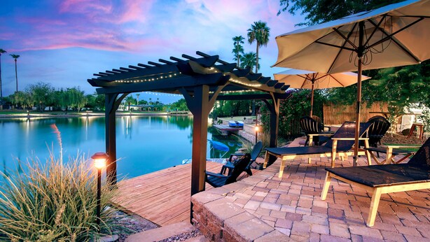 An outdoor patio with a pergola, seating area, and a view of a lake. - Lake Front Paradise, Pool and Hot Tub-Bubbly (Mesa)