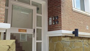 Entrada de un edificio con un cartel que dice 'South Apartments'.