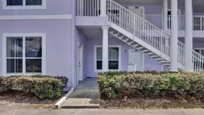 A two-story building with a purple exterior, white railings, and a central staircase. - Huge Screened Patio That Overlooks Lake Buck, Near Famous Attractions!! (Kissimmee)