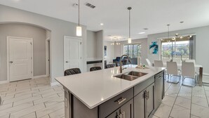 A modern kitchen with a large island, stainless steel appliances, and pendant lighting. - Storey Lake Resort, Private Pool, and Much More!! (Kissimmee)